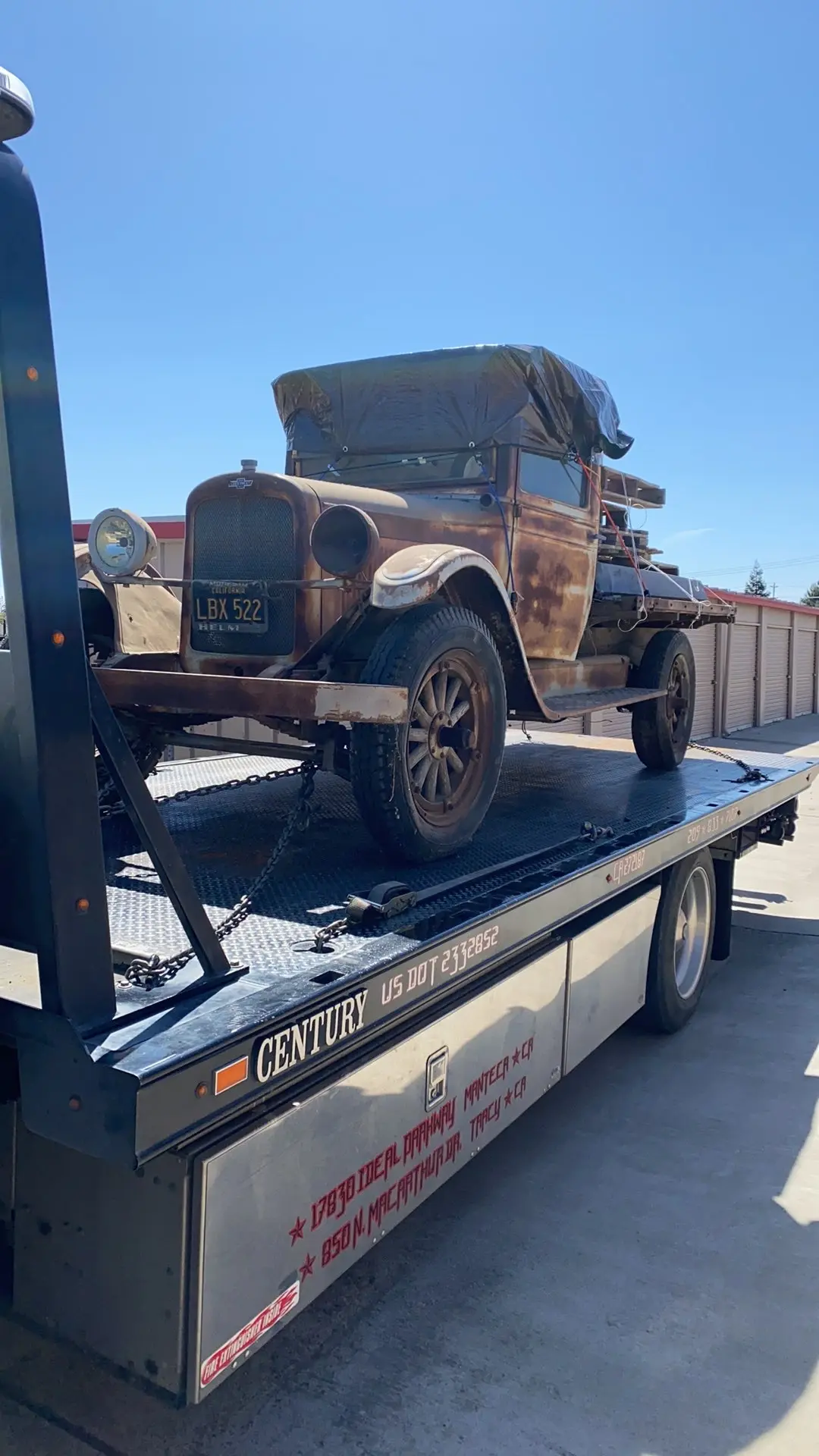 Antique vehicle loaded on an All Star flatbed for transport.